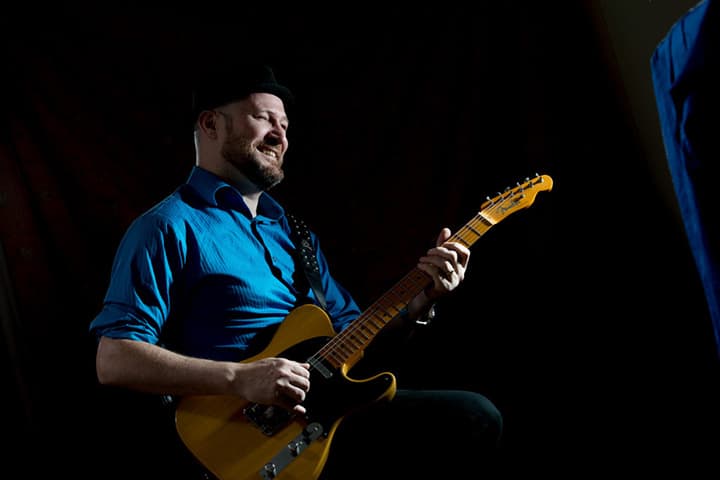 Phil wearing a Blue Shirt, playing his Telecaster